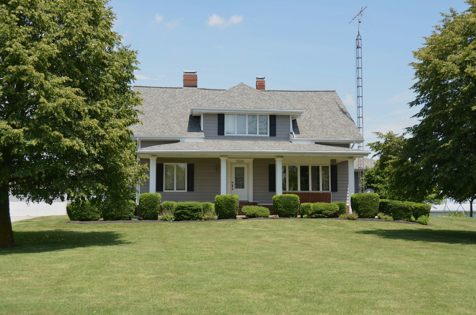 A house with a covered porch on an open lawn